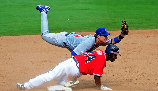 Die Haltung von Darwin Barney (h.) von den Chicago Cubs gegen die Atlanta Braves ähnelt hier auffällig einer Übung bei der Krankengymnastik und keiner Aktion im Baseball