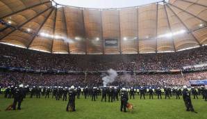 Nach gut zehn Minuten erlischt das Feuer im Hamburger Block langsam. Die Polizei bleibt dennoch auf dem Rasen.