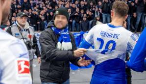 Ein Fan reisst nach dem 1:4 von Hertha BSC gegen Union Berlin am Trikot von Lucas Tousart. Die Herthaspieler legten ihre Trikots auf die Laufbahn vor der Fankurve.