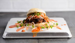 Bao to the Pork: Die World Champions Chicago Cubs setzen auf asiatischen Touch. Geräuchertes Pulled Pork, kombiniert mit Asia-Sauce, eingelegtem Winterrettich und Karotten, Gurken und Jalapeno-Gewürz auf einem gedämpften Bao-Brötchen